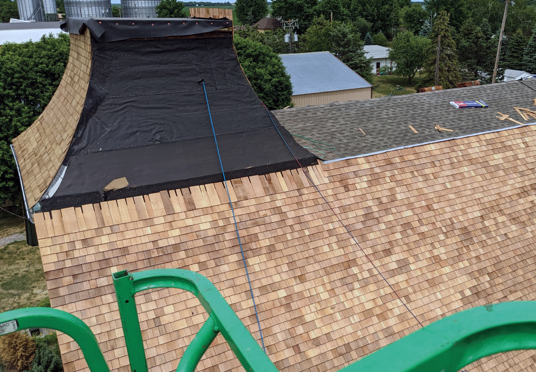 Inspector reviewing documentation on a completed roof in late afternoon light