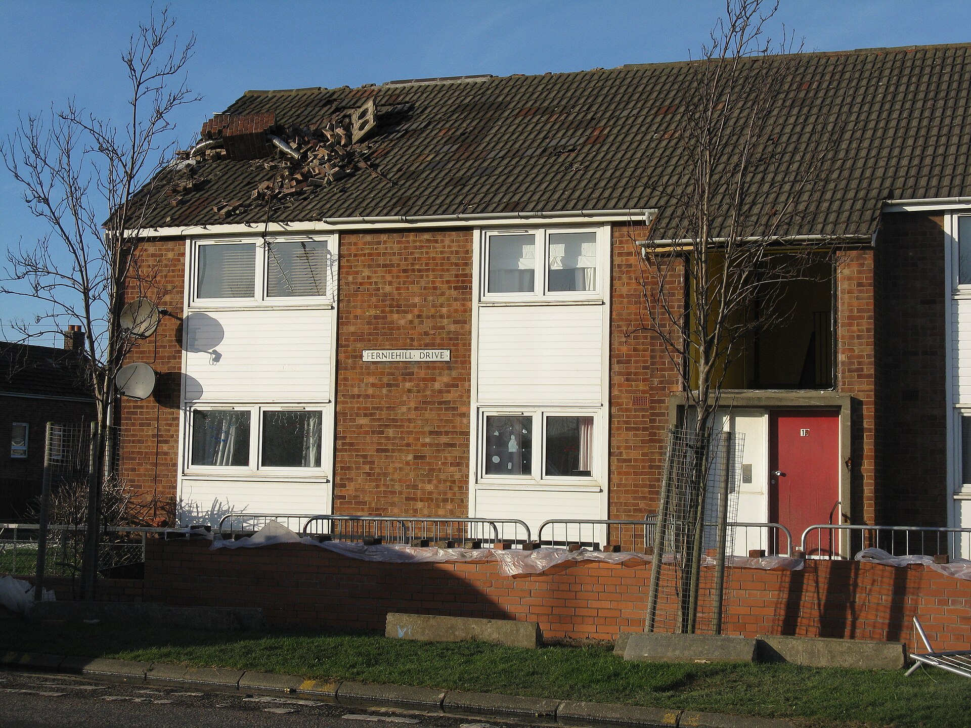 Roof with lifted and missing shingles after a wind storm